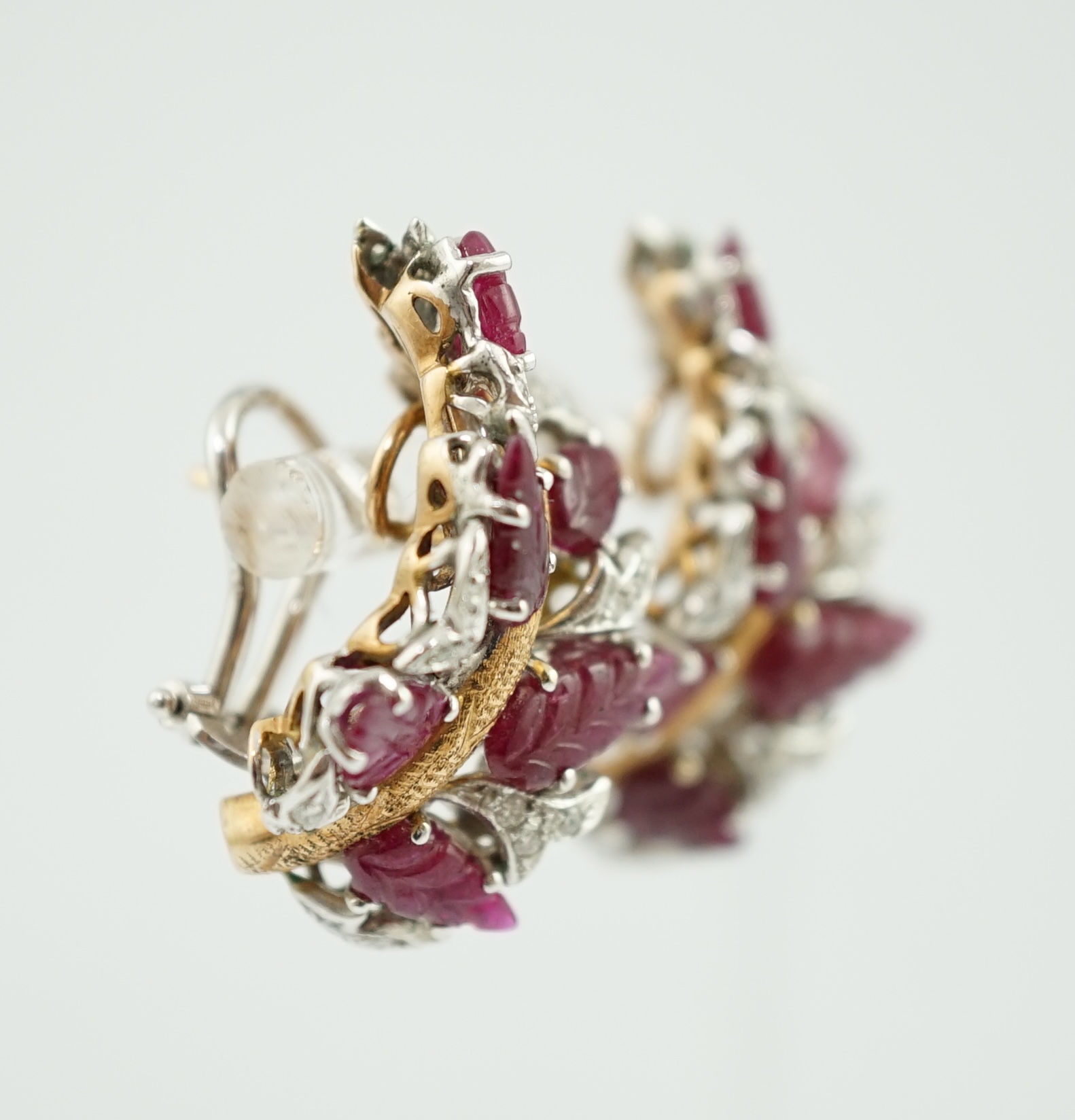 A modern pair of 18k, ruby and diamond cluster set demi-lune earrings